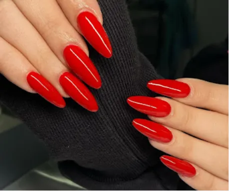 Unhas alongadas em vermelho, acabamento em amêndoa